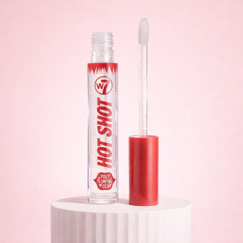 Open plumping lip oil with doe foot applicator showing glossy oil texture on a soft pink background