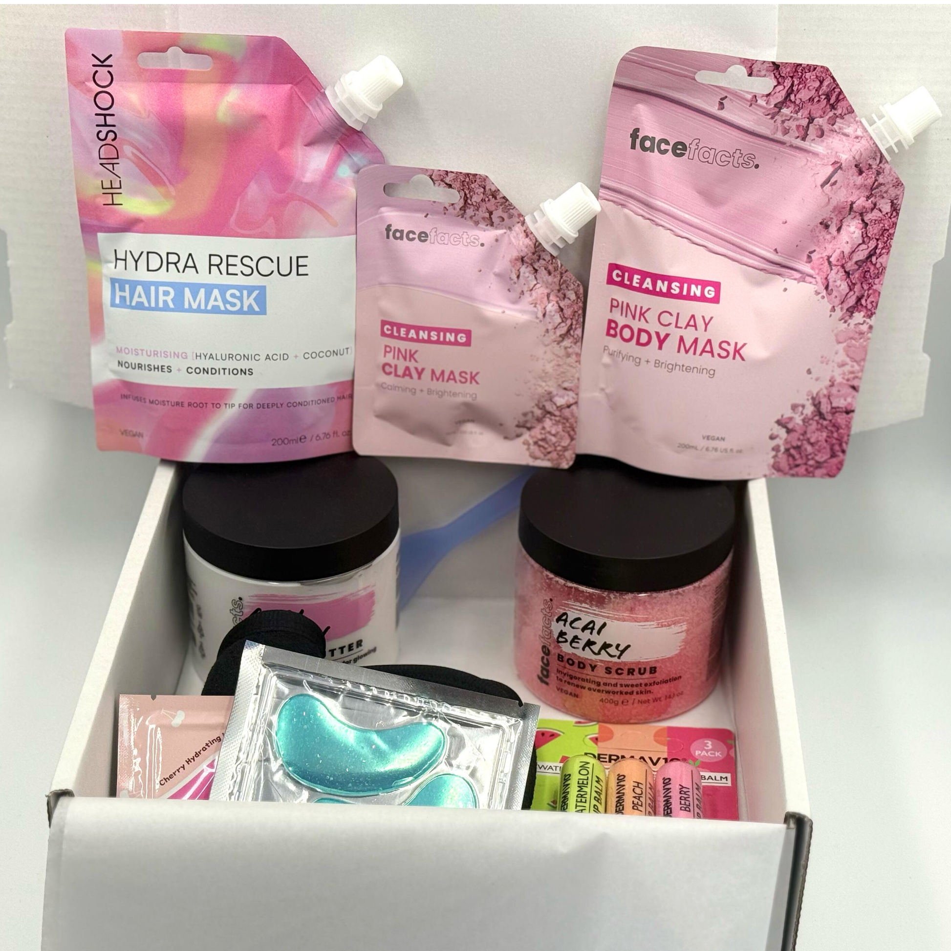 Pink clay spa gift set arranged inside gift box showing masks, scrub, body butter, eye patches and lip care items