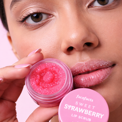 Beauty close up showing strawberry sugar lip scrub exfoliating lips for hydration and smooth texture using Face Facts lip care treatment product.